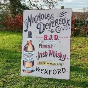 Vintage Nicholas Devereux Irish Whisky tin sign with bold lettering and bottle illustration – Wexford distillery memorabilia.